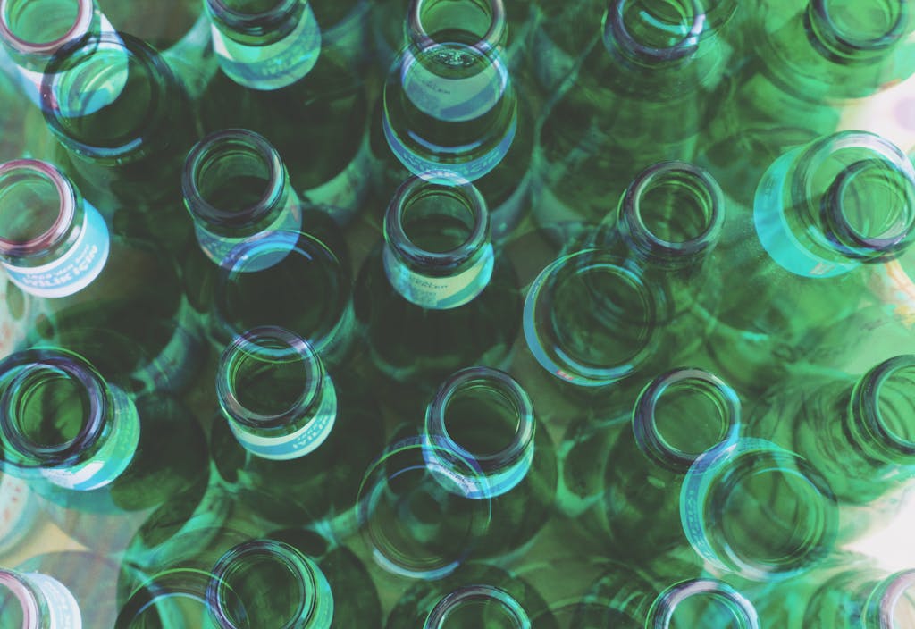 Top view of overlapping green glass bottles creating an abstract pattern.